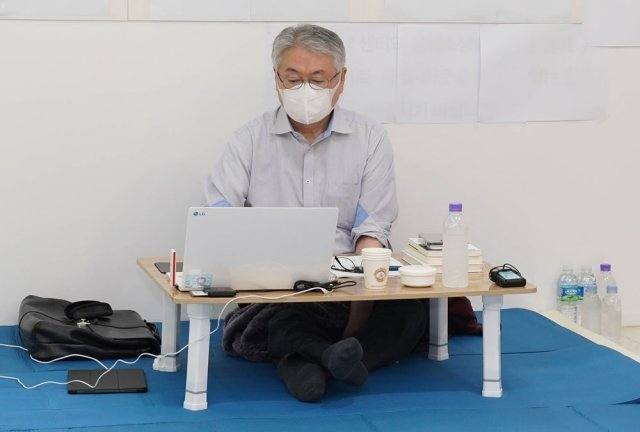 김용익 이사장이 원주 건보공단 본부 로비에서 15일 이틀째 단식 농성을 이어가면서 업무를 보고 있다. [국민건강보험공단 제공]