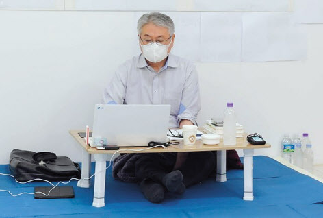 김용익 이사징이 원주 건보공단 본부 로비에서 15일 이틀째 단식 농성을 이어가면서 업무를 보고 있다.  [국민건강보험공단 제공]