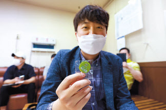 민방위 대원인 이준석 국민의힘 대표가 15일 오전 서울 노원구 한 병원에서 코로나19 얀센 백신을 접종했다. 접종을 마치고 이 대표가 배지를 들어보이고 있다. [연합]