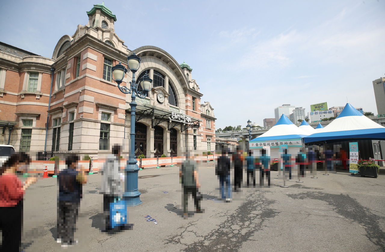 지난 14일 서울역광장에 마련된 중구 임시선별검사소에서 시민들이 코로나19 선별검사를 받기 위해 줄을 서 있다. [연합]