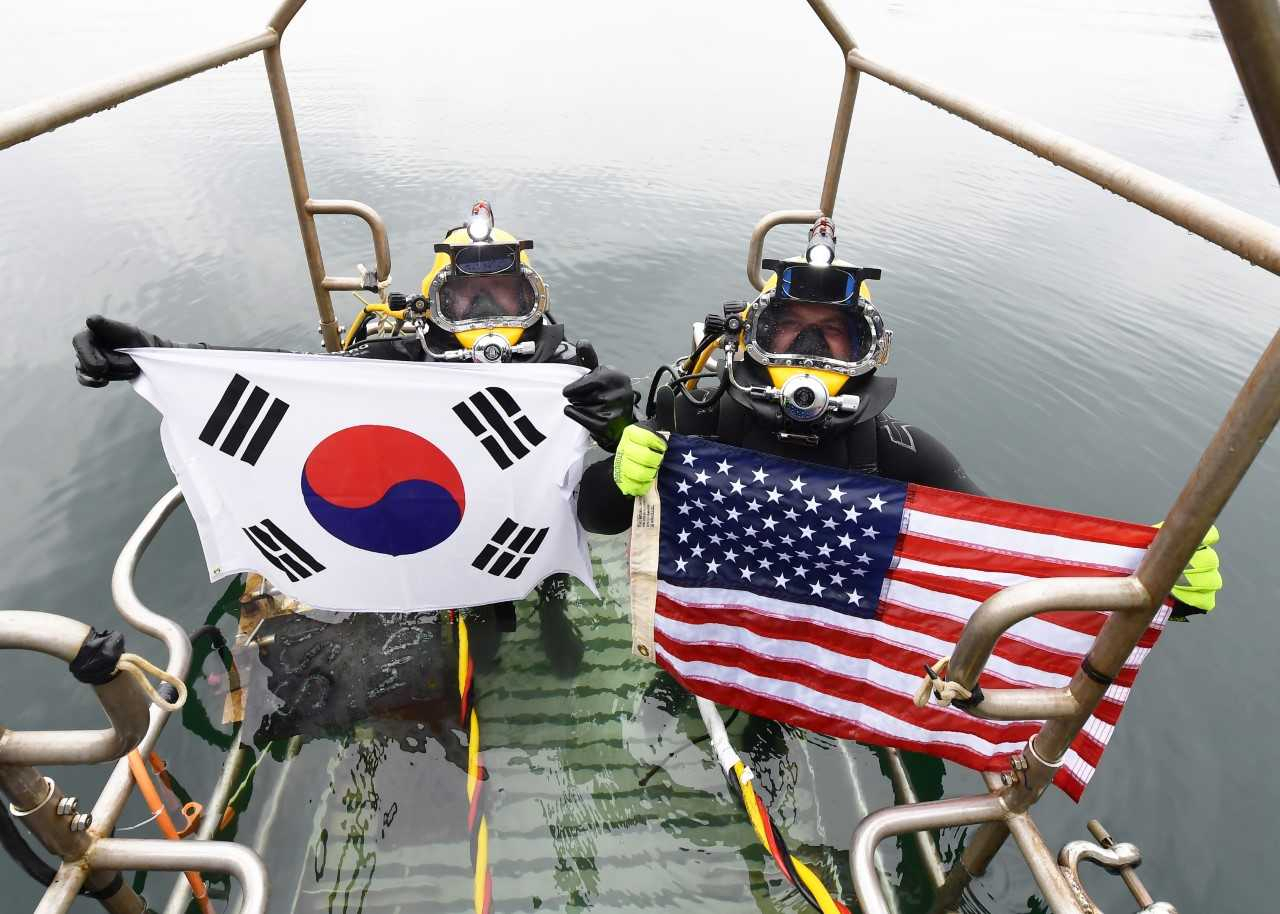 한국과 미국은 9~15일 경남 진해만 일대에서 해상재난 발생에 대비한 한미 연합 구조전 훈련을 실시했다. 한미 구조대원들이 손상 함정 긴급 복구훈련을 마치고 태극기와 성조기를 펼치며 한미동맹 의지를 과시하고 있다. [해군 제공]