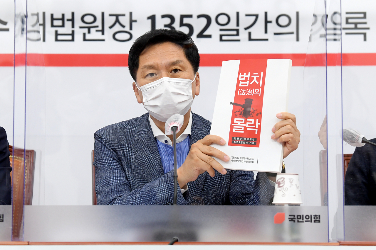 김기현 국민의힘 원내대표가 15일 서울 여의도 국회에서 열린 '김명수 대법원장 비리 백서' 발간 기자회견에서 '법치의 몰락' 백서를 보여주고 있다. [헤럴드경제=이상섭 기자]