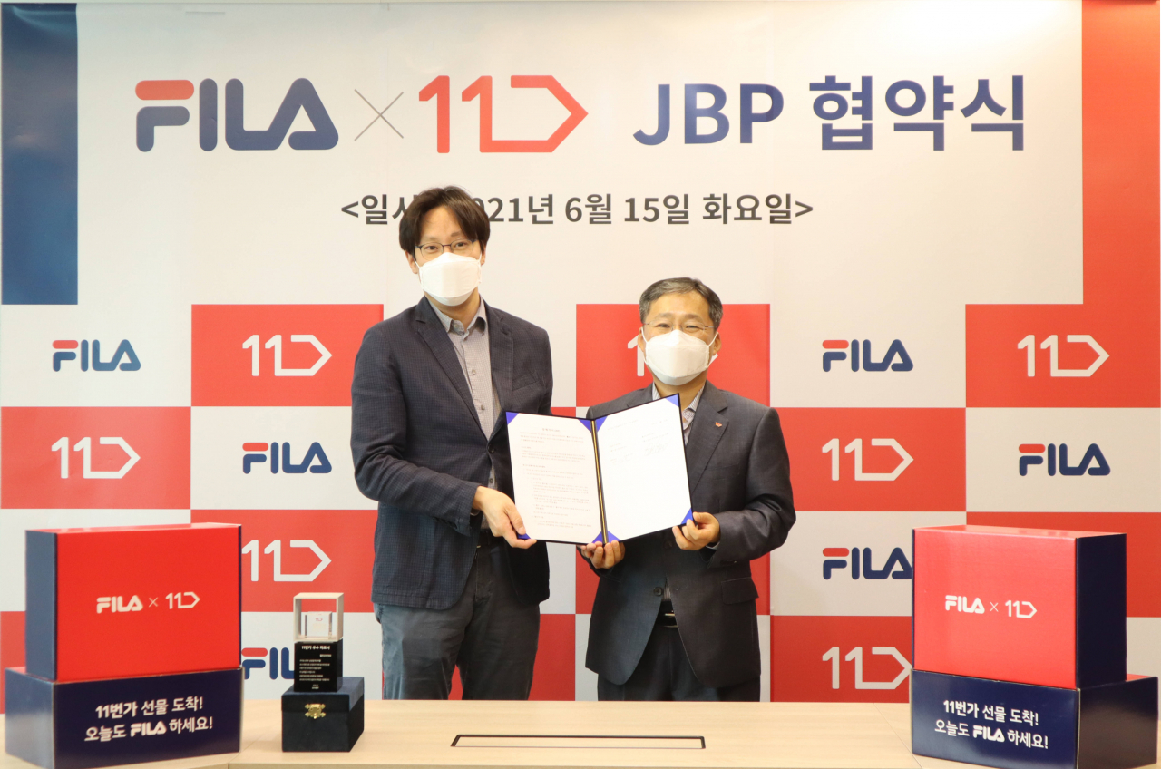 11번가는 지난 15일 오전 서울 강동구 휠라코리아 본사에서 휠라코리아와 업무 제휴 협약(JBP)을 맺었다. 사진은 11번가 이상호 사장(사진 오른쪽), 휠라코리아 윤근창 대표(사진 왼쪽)가 기념촬영을 하고 있는 모습.[11번가 제공]