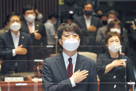 국민의힘 이준석 신임 대표가 14일 국회에서 열린 의원총회에서 국기에 대한 경례를 하고 있다. [연합]