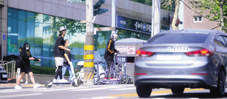 공유 전동킥보드의 헬멧 미착용 단속이 시작된 가운데, 시민들이 킥보드를 이용하고 있다. 박해묵 기자