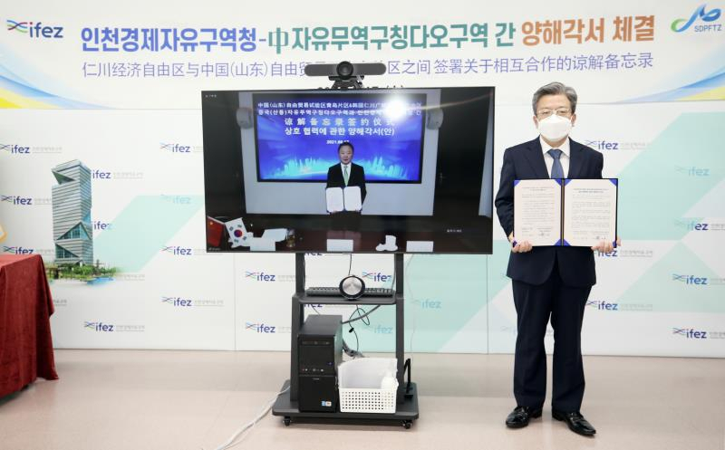 지난 16일 이원재 인천경제자유구역청장〈사진 우측〉과 조사옥(趙士玉) 중국(산둥)자유무역칭다오구역 주임이 상호 업무협약을 온라인으로 체결하고 기념포즈를 취하고 있다.〈사진제공=인천경제자유구역청〉