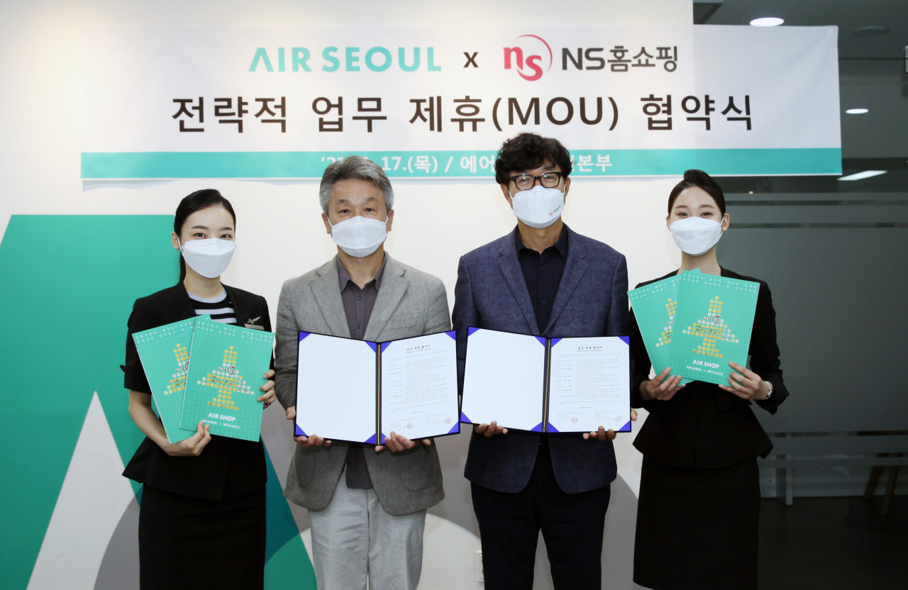 김용만 NS홈쇼핑 SB사업본부 상무(오른쪽에서 두 번째)가 서울 강서구 에어서울 사옥에서 기내 홈쇼핑 서비스 제공을 위한 전략적 업무제휴 협약식을 갖고, 김웅 에어서울 안전본부 상무(왼쪽에서 두 번째)와 기념 촬영을 하고 있다. [NS홈쇼핑 제공]