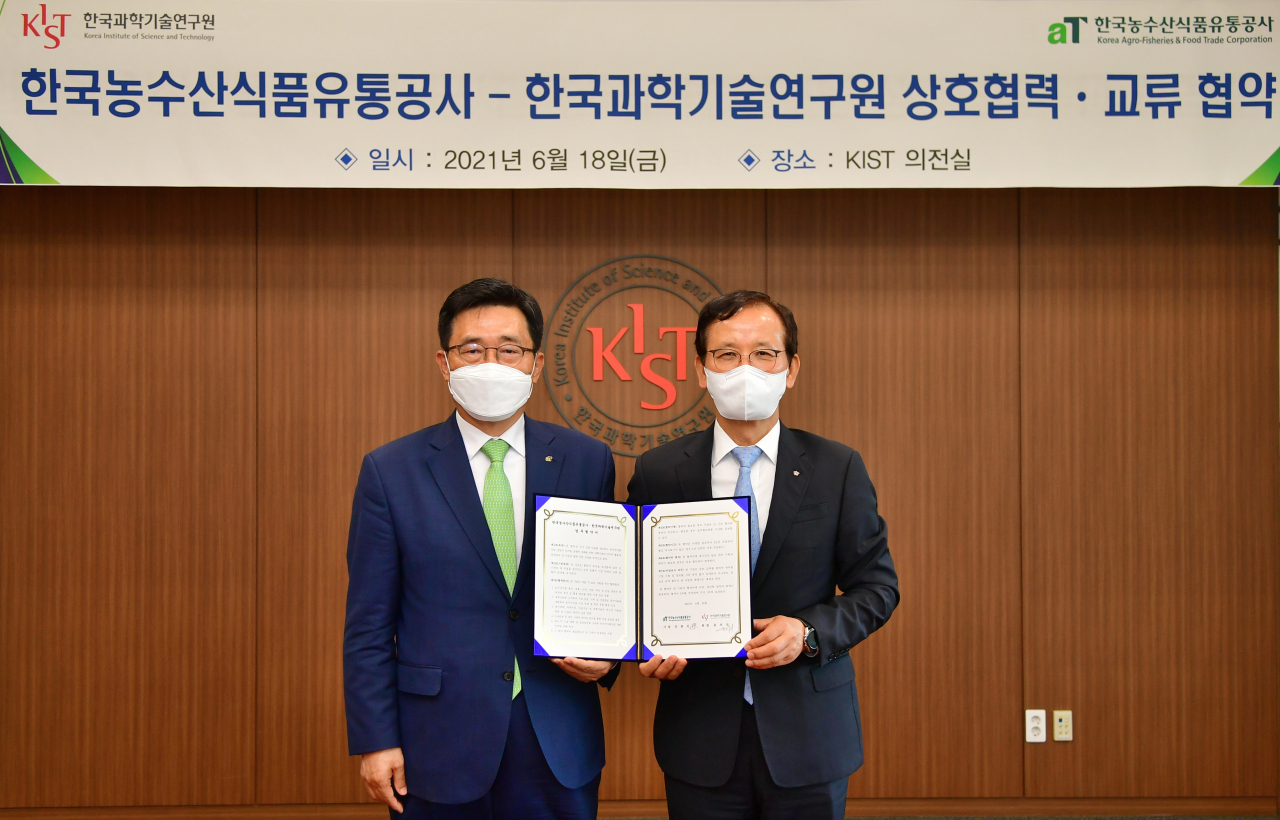 김춘진(왼쪽) 한국농수산식품 유통공사 사장과 윤석진 KIST원장이 협약서에 서명한 후 기념촬영을 하고 있다.[KIST 제공]