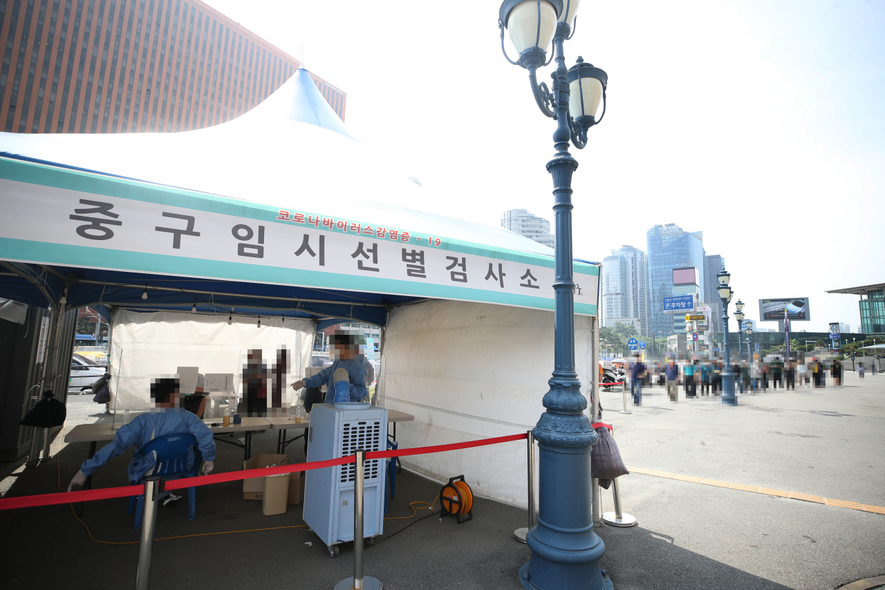 14일 오전 서울역 광장에 마련된 중구임시선별검사소에서 시민들이 신종 코로나바이러스 감염증(코로나19) 선별검사를 받기 위해 줄을 서 있다. 보통 주말·휴일에는 검사 건수가 대폭 줄면서 환자 수도 감소하는 경향이다. [연합]