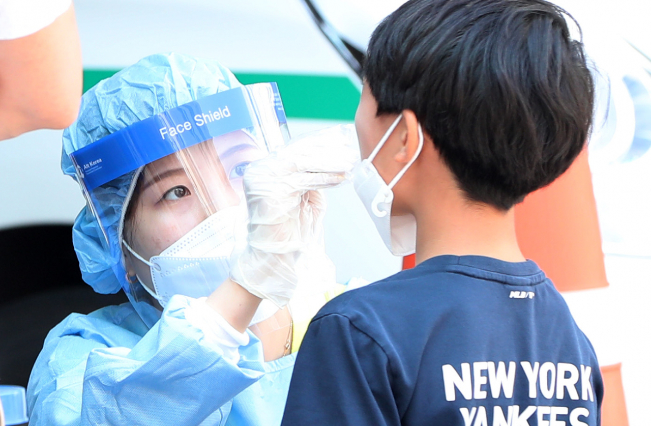 21일 강원 춘천시보건소에 마련된 선별진료소에서 어린이가 코로나19 검사를 받고 있다. 이날 춘천의 한 초등학교에서 학생 1명이 코로나19 확진을 받아 해당 학교의 학생 등교가 임시 중단됐다. [연합]