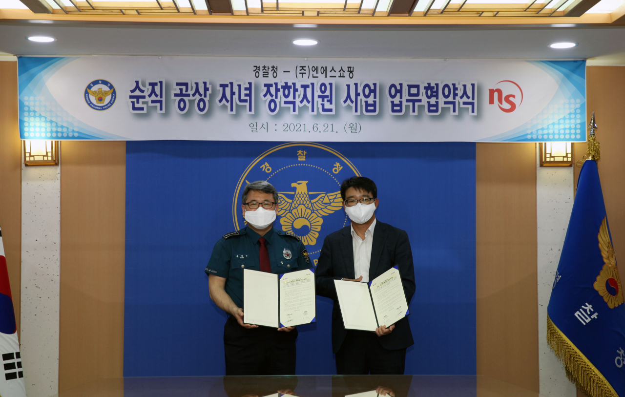 NS홈쇼핑 사회공헌위원장 이상근 이사(오른쪽)와 경찰청 복지정책담당관 홍명곤 총경이 '순직 공상 자녀 장학지원 사업을 위한 업무 협약' 체결 후, 기념촬영을 하고 있는 모습. [NS홈쇼핑 제공]