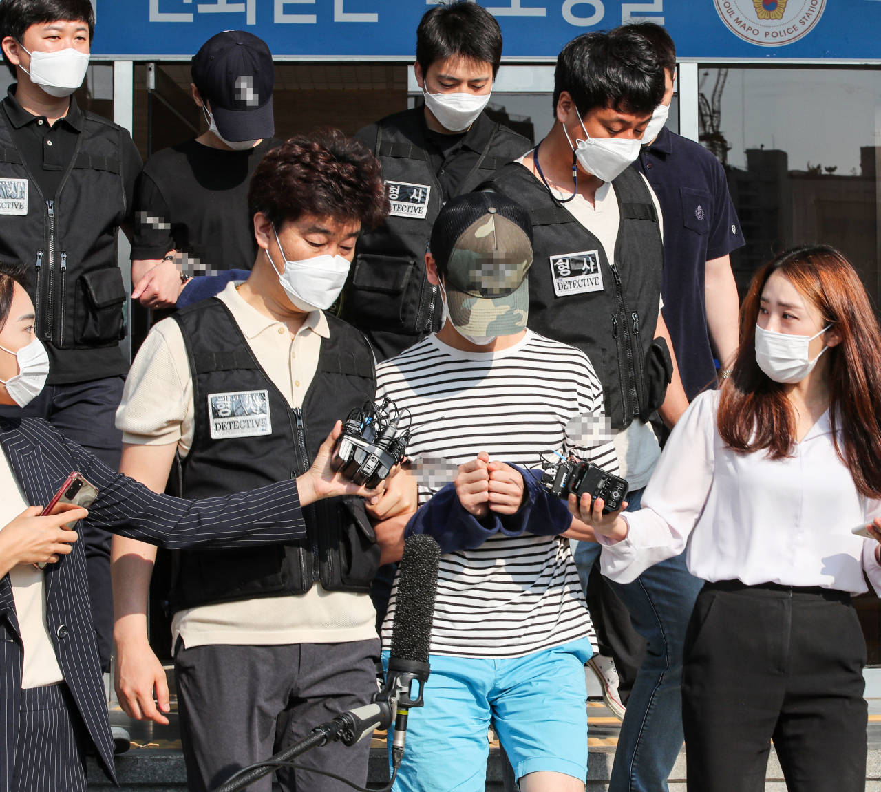 오피스텔에서 친구를 감금해 살해한 혐의를 받는 피의자 안모 씨와 김모 씨가 22일 오전 검찰로 송치되기 위해 서울 마포경찰서를 나서고 있다. [연합]