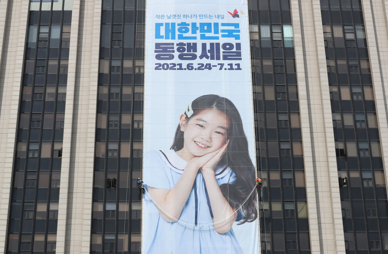 19일 오전 정부서울청사 외벽에 '대한민국 동행세일' 홍보를 위한 대형 플래카드가 설치되고 있다. 중소벤처기업부는 코로나19 위기 극복과 중소기업·소상공인의 판로 개척을 위해 대규모 할인 행사인 2021 대한민국 동행세일'을 지난해에 이어 올해 다시 개최한다고 밝혔다. 오는 24일부터 다음 달 11일까지 18일간 온라인 중심으로 진행된다. [연합]