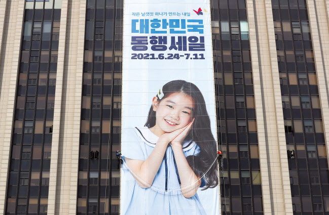 정부서울청사 외벽에 ‘대한민국 동행세일’ 홍보를 위한 대형 플래카드가 걸려있다. 코로나19 위기 극복과 중소기업·소상공인의 판로 개척을 위한 대규모 할인 행사인 ‘2021 대한민국 동행세일’이 오는 24일부터 다음 달 11일까지 18일간 온라인 중심으로 진행된다. [연합]
