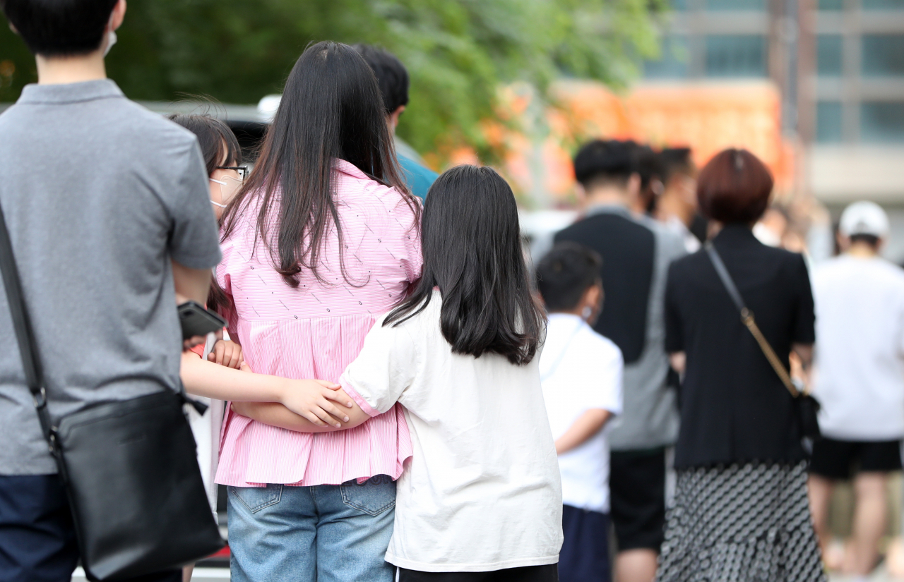22일 강원 춘천시보건소 인근에서 코로나19 검사를 받기 위해 기다리는 시민들이 줄을 잇고 있다. 이날 춘천의 한 초등학교에서는 학생과 교사 등 9명이 코로나19 확진을 받아 등교가 임시 중단됐다. [연합]