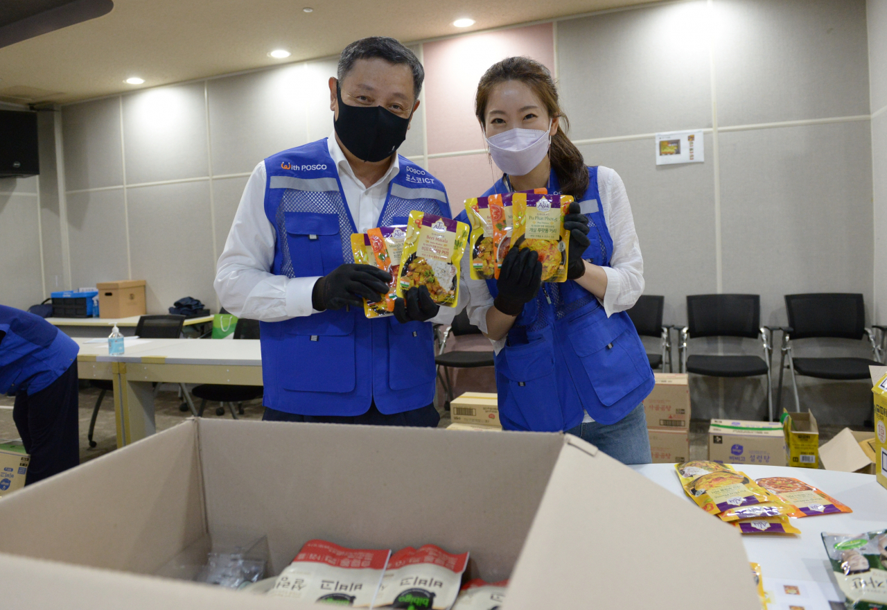 정덕균 포스코ICT 사장이 판교사옥에서 임직원들과 함께 지역 결식아동들에게 전달할 '푸드박스'를 포장하고 있다. [포스코ICT 제공]