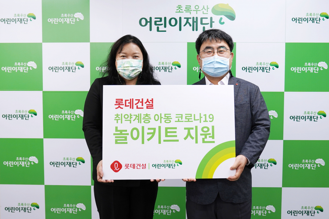 초록우산어린이재단 최운정 본부장과 롯데건설 한정호 상무(오른쪽)가 서울지역 아동을 위한 ‘놀이 키트’ 전달식을 진행했다.[롯데건설 제공]
