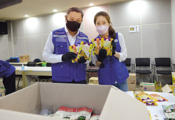 정덕균(왼쪽) 포스코ICT 사장이 판교사옥에서 임직원들과 함께 지역 결식아동들에게 전달할 ‘푸드박스’를 포장하고 있다. [포스코ICT 제공]