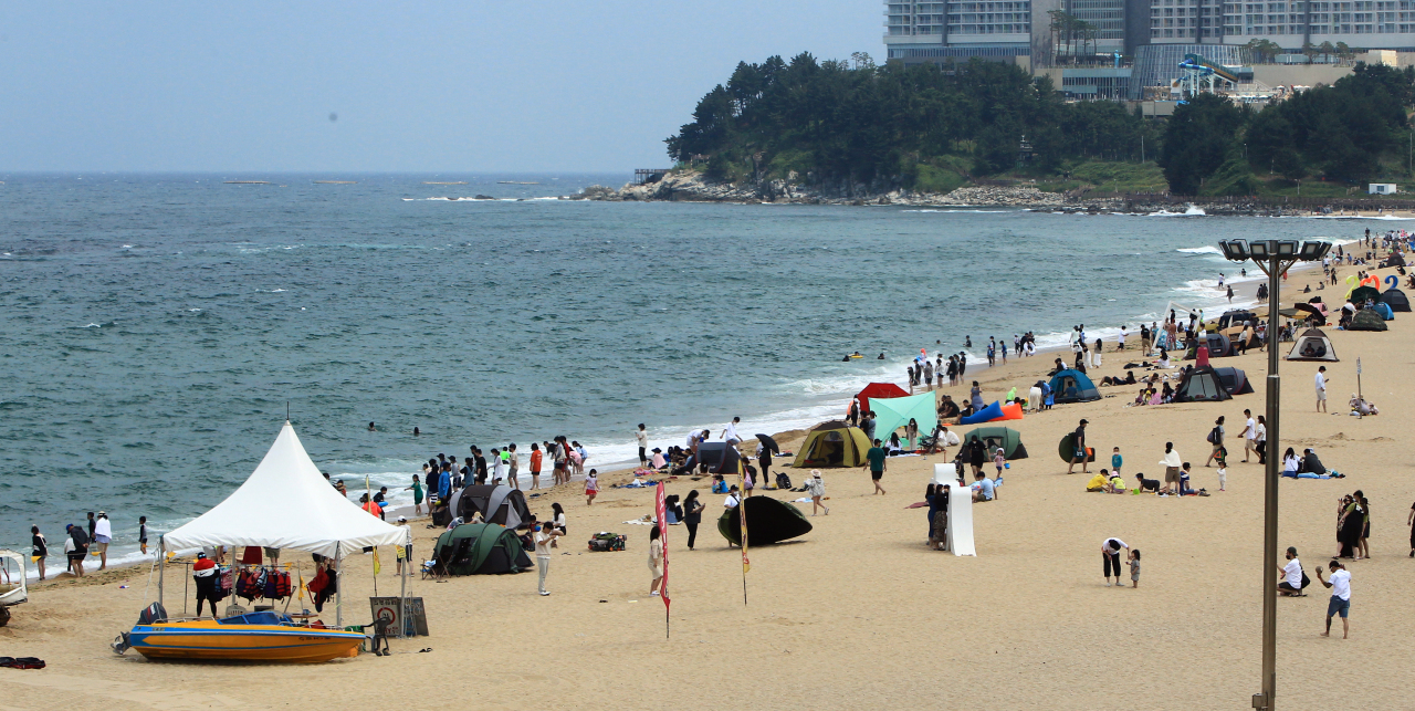 A beach in Sokcho, Gangwon Province, on Sunday is filled with visitors enjoying their day off. (Yonhap)