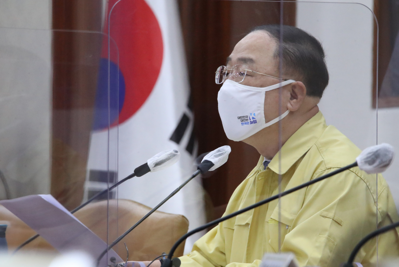 홍남기 부총리 겸 기획재정부 장관은 24일 주52시간제 도입 연착륙 방안과 관련 “근로시간 단축과정에서 신규인력 채용기업이 고용을 유지하면 최대 월 120만원을 최장 2년간 지원하고 신규채용이 어려운 뿌리기업·지방소재기업에 외국인력을 우선 배정할 계획”이라고 말했다. 사진은 24일 정부서울청사에서 열린 제39차 비상경제 중앙대책본부 회의를 주재하고 있는 홍남기 경제부총리 겸 기획재정부 장관. [연합]