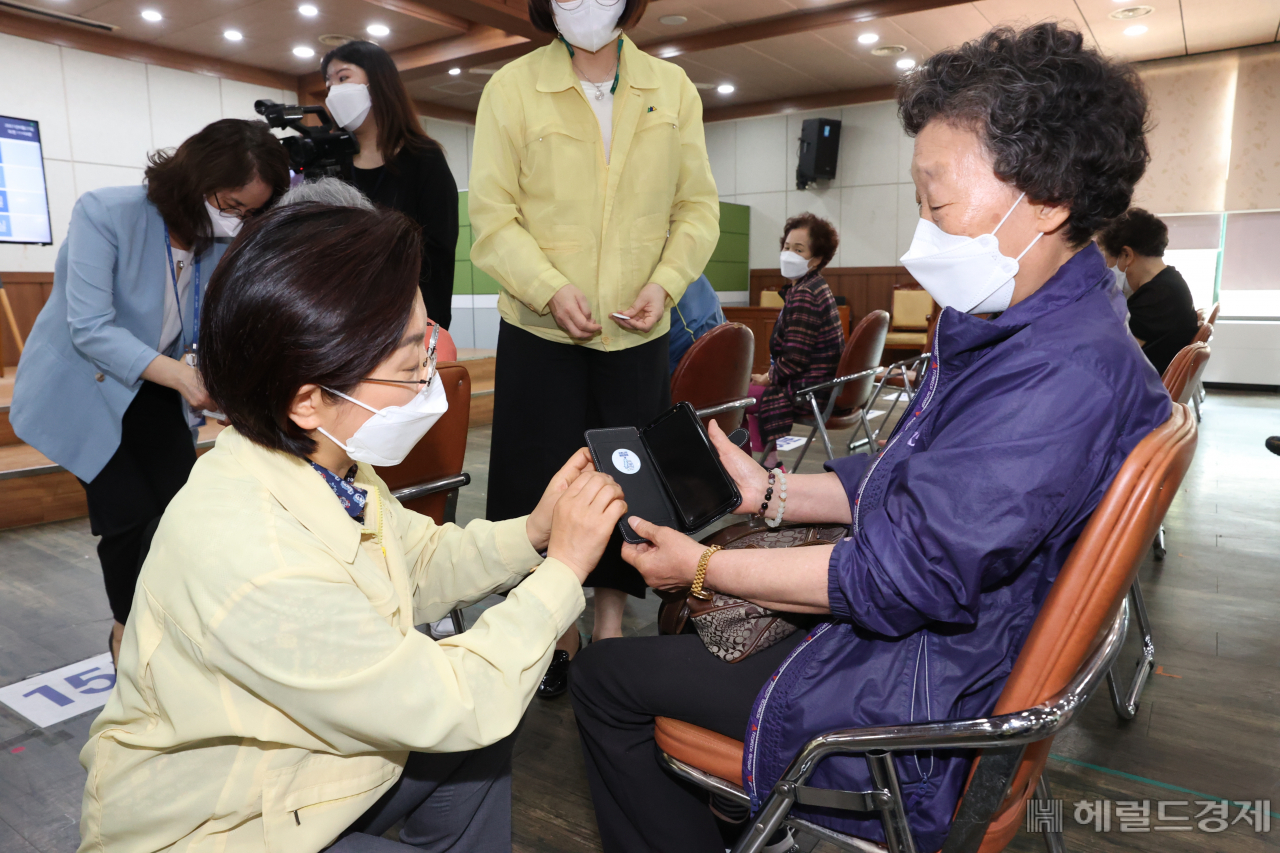 김미경 구청장이 백신 접종을 맞은 지역 주민에게 접종자임을 보여주는 스티커를 붙여주고 있다 [은평구 제공]