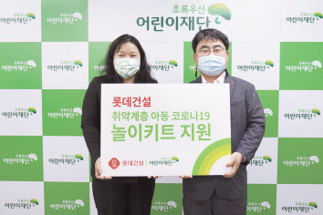 초록우산어린이재단 최운정 본부장과 롯데건설 한정호(오른쪽) 상무가 서울지역 아동을 위한 ‘놀이 키트’ 전달식을 진행했다. [롯데건설 제공]