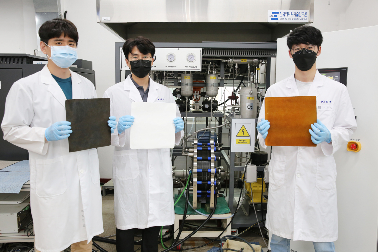 김창희 박사 연구팀이 10kW 알칼라인 수전해 스택 앞에서 전극과 분리막을 들어보이고 있다.[한국에너지기술연구원 제공]