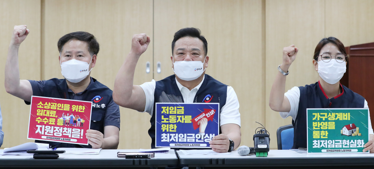 최저임금위원회 근로자위원인 이동호(가운데) 한국노총 사무총장과 박희은(오른쪽) 민주노총 부위원장 등 위원들이 24일 오후 세종시 정부세종청사에서 제5차 전원회의를 앞두고 열린 2022년 적용 최저임금 노동계 최초요구 발표 기자간담회에서 구호를 외치고 있다. [연합]