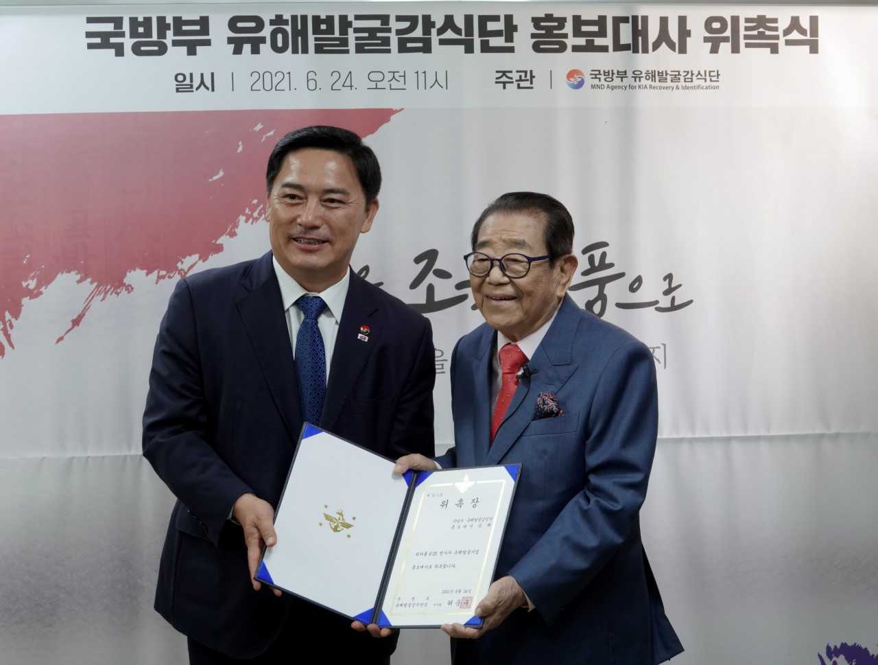 허욱구 국방부유해발굴단장이 원로 방송인 송해(오른쪽) 씨에게 유해발굴사업 홍보대사 위촉장을 전달하고 있다. [국방부 제공]