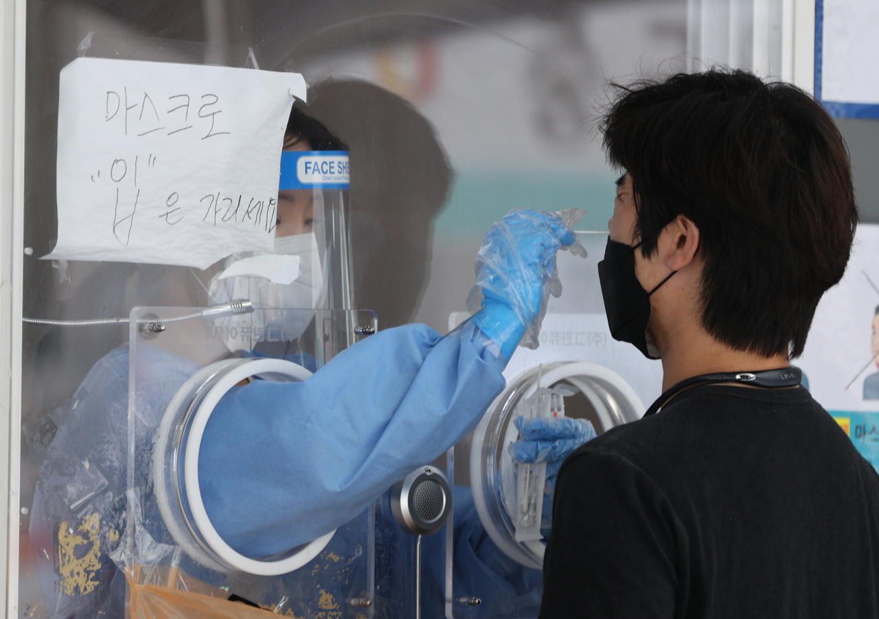 25일 오후 서울 중구 서울역 광장에 마련된 중구임시선별검사소에서 한 시민이 신종 코로나바이러스 감염증(코로나19) 선별검사를 받고 있다. [연합]