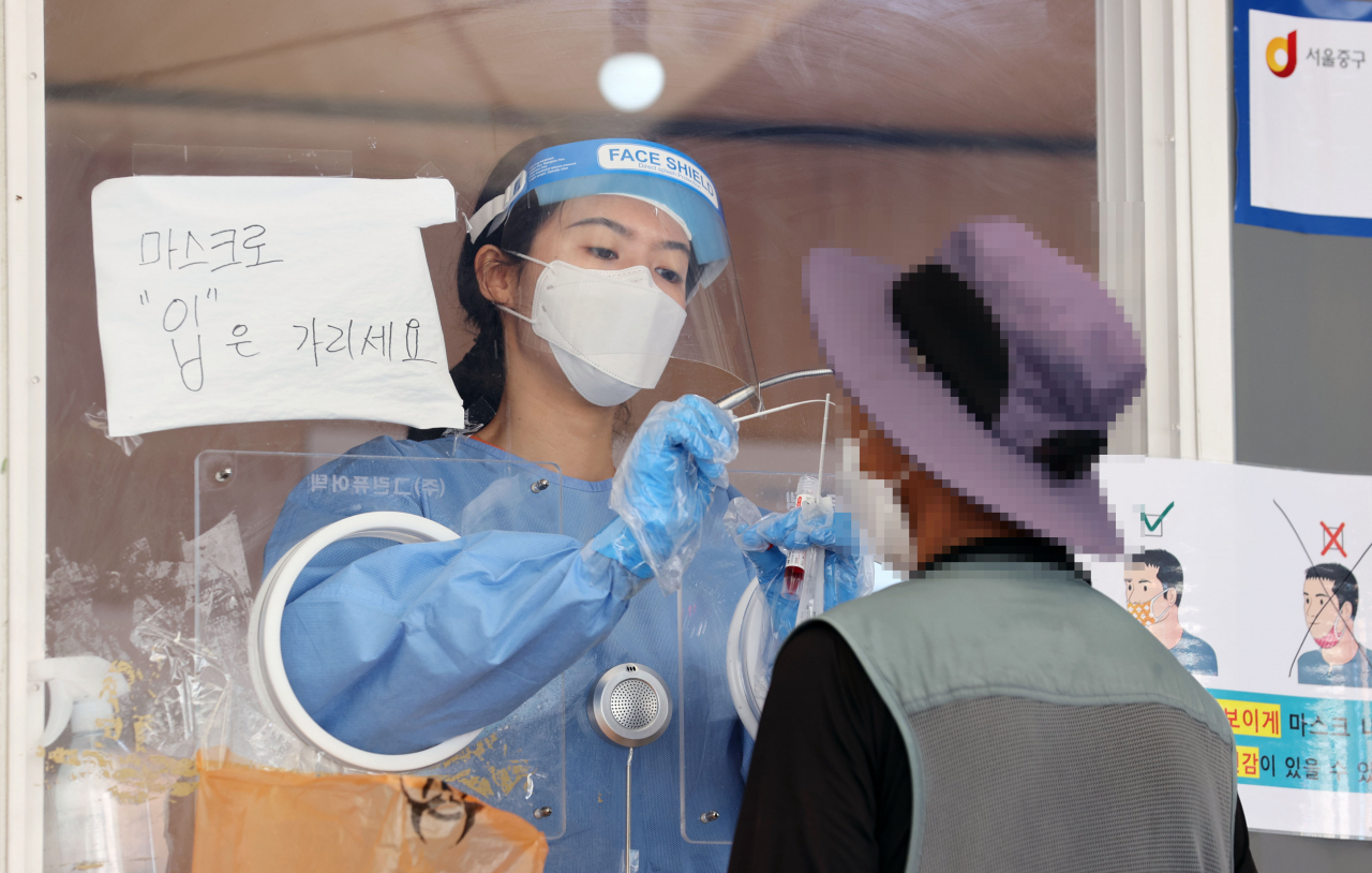 27일 서울역 광장에 마련된 신종 코로나바이러스 감염증(코로나19) 임시 선별검사소에서 의료진이 검체를 채취하고 있다. 연합뉴스