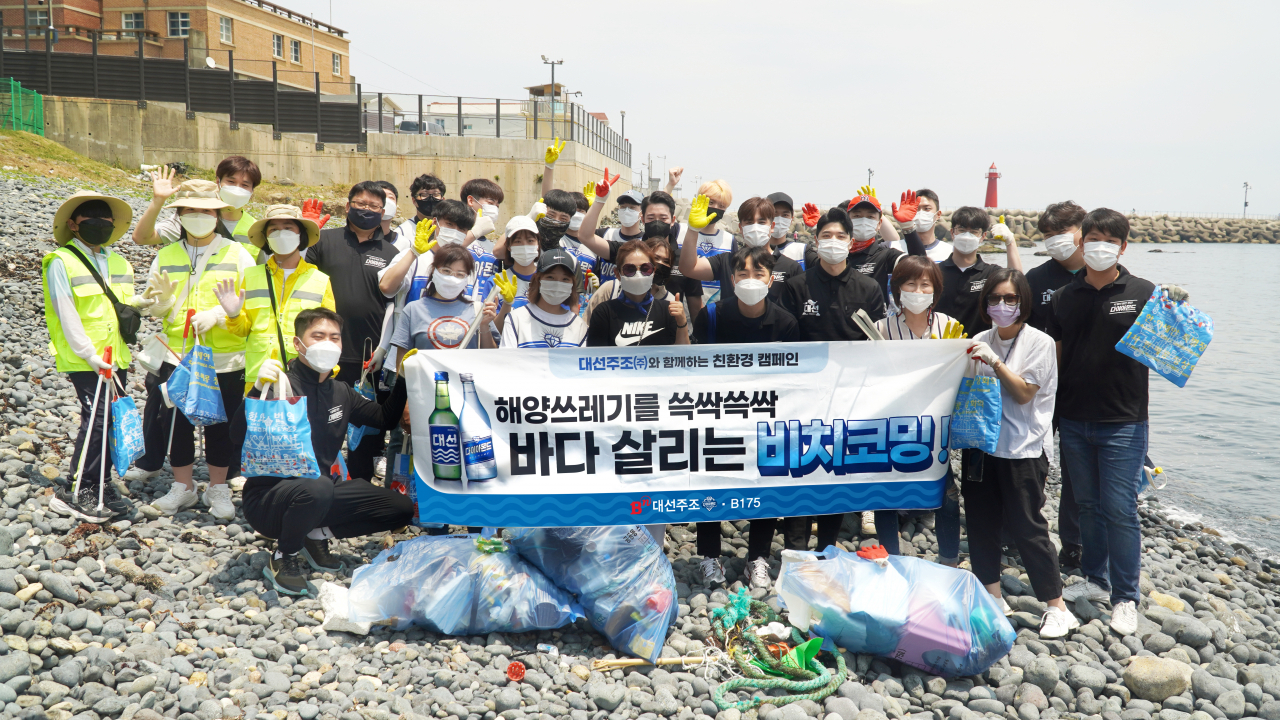 지난 26일 부산 해운대 청사포에서 대선주조 임직원과 시민들이 해안 정화 활동 비치코밍을 진행했다. [대선주조 제공]