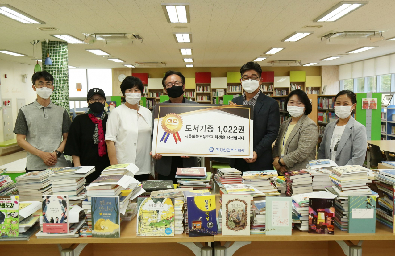 애경산업은 마포구 서울하늘초등학교에서 지역사회 청소년들을 위한 ‘사랑의 도서기증’ 전달식을 진행했다. 애경산업 송기복 상무(왼쪽에서 다섯번째), 서울하늘초등학교 김재영 학교장(왼쪽에서 네번째), 마포구 최은하 구의원(왼쪽에서 세번째) 등이 참석해 기념촬영을 하고 있다. [애경산업 제공]