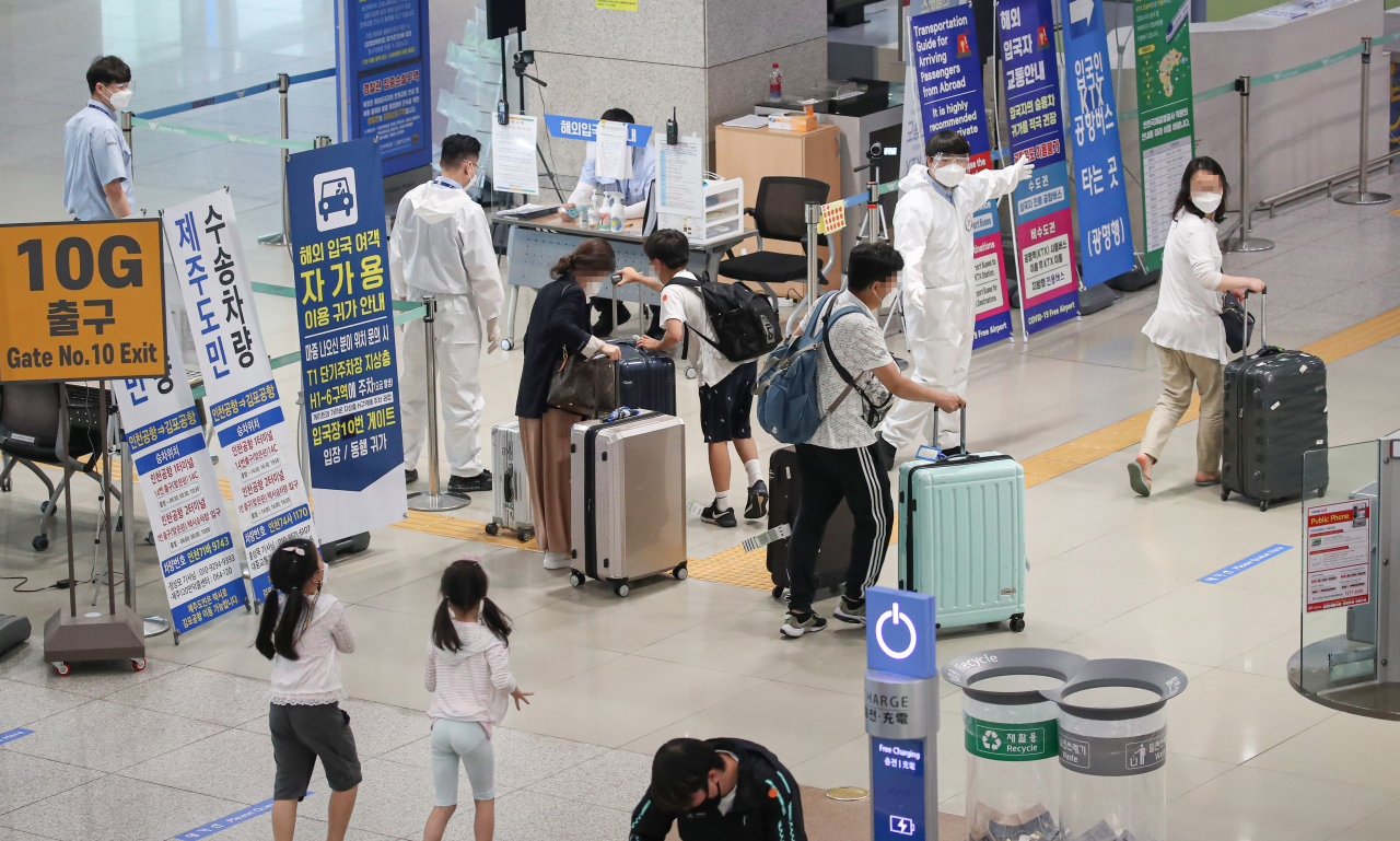 국내 신종 코로나바이러스감염증(코로나19) 신규 확진자 수가 600명대에 육박한 29일 오전 인천국제공항 제1여객터미널 입국장에서 입국자들이 방역관계자의 안내를 받으며 이동하고 있다. 연합뉴스