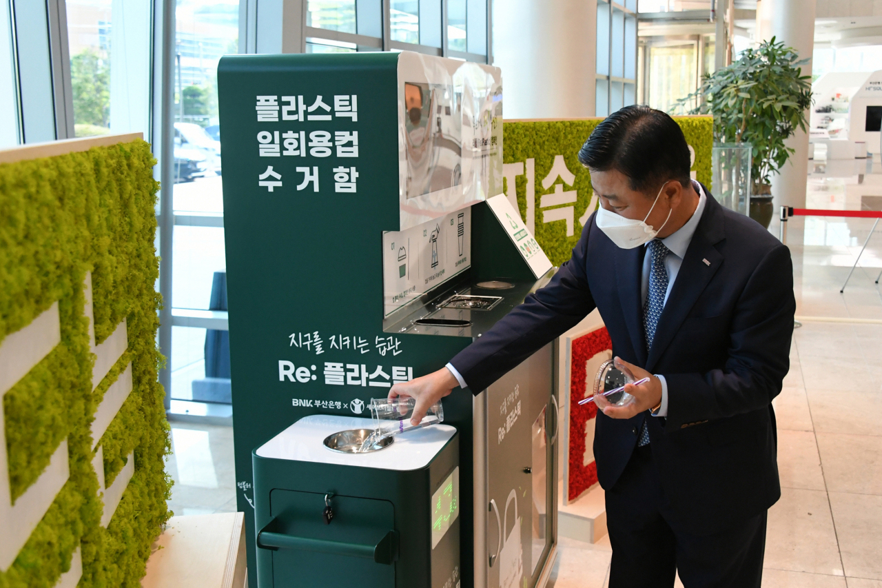 BNK부산은행 안감찬 은행장이 지난 28일 오후 본점 1층에서 ‘리플 캠페인(Re : Plastic)’의 일환으로 설치된 플라스틱 컵 수거함을 직접 사용하는 모습 [부산은행 제공]