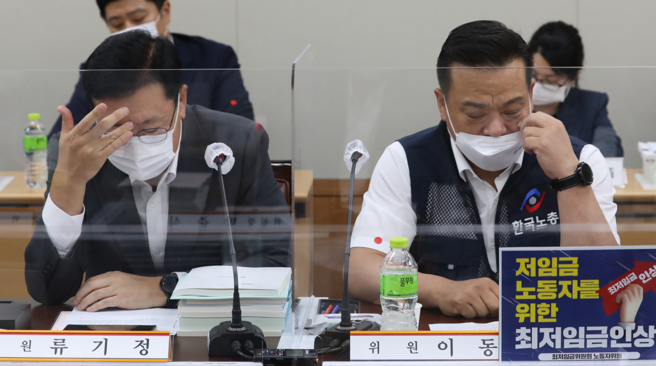 29일 오후 세종시 정부세종청사 최저임금위원회 회의실에서 열린 6차 전원회의에서 사용자위원인 류기정 경총 전무(왼쪽)와 근로자위원인 이동호 한국노총 사무총장이 고민하는 표정을 하고 있다. [연합]