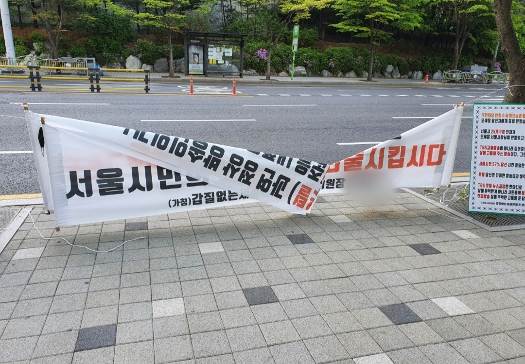 지난 4월 중순 서울시 마포구 상암동 교통방송(TBS) 앞에 걸린 ‘김어준 퇴출’을 요구하는 현수막이 훼손돼 있다. [독자 제공]