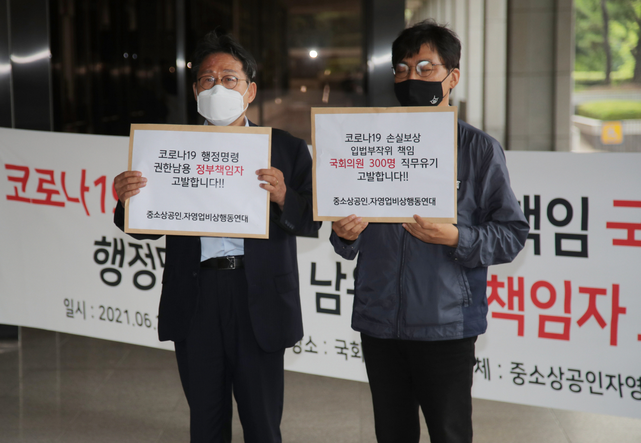 중소상공인·자영업자비상행동연대 관계자들이 지난 28일 오전 서울 서초구 서울중앙지검에서 국회의원 300명과 정부책임자들을 각각 코로나19 손실보상 입법부작위와 행정명령 권한남용 혐의로 고발하기 위해 민원실로 향하고 있다. [연합]