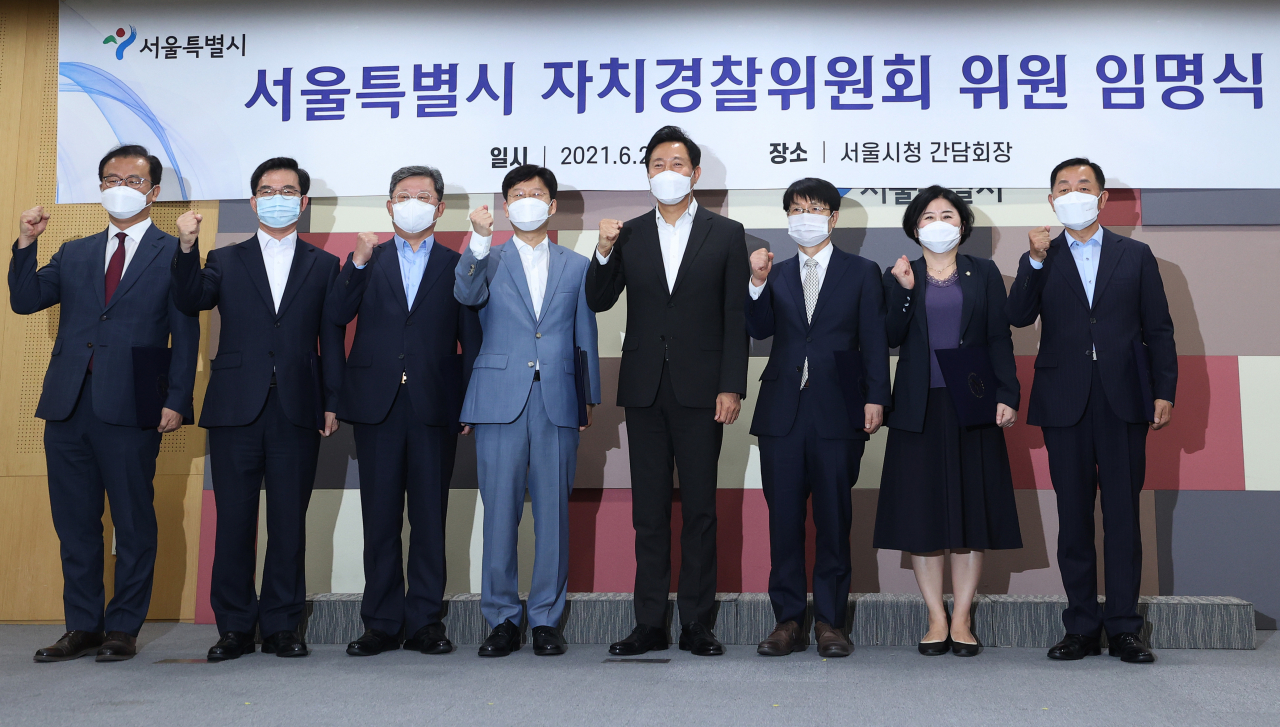 오세훈(오른쪽 네 번째) 서울시장이 지난달 25일 오후 서울 중구 서울시청에서 열린 서울자치경찰위원 임명식에서 초대 위원장인 김학배(오른쪽 세 번째) 전 울산경찰청장 등 위원들에게 임명장을 수여한 뒤 기념촬영을 하고 있다. [연합]