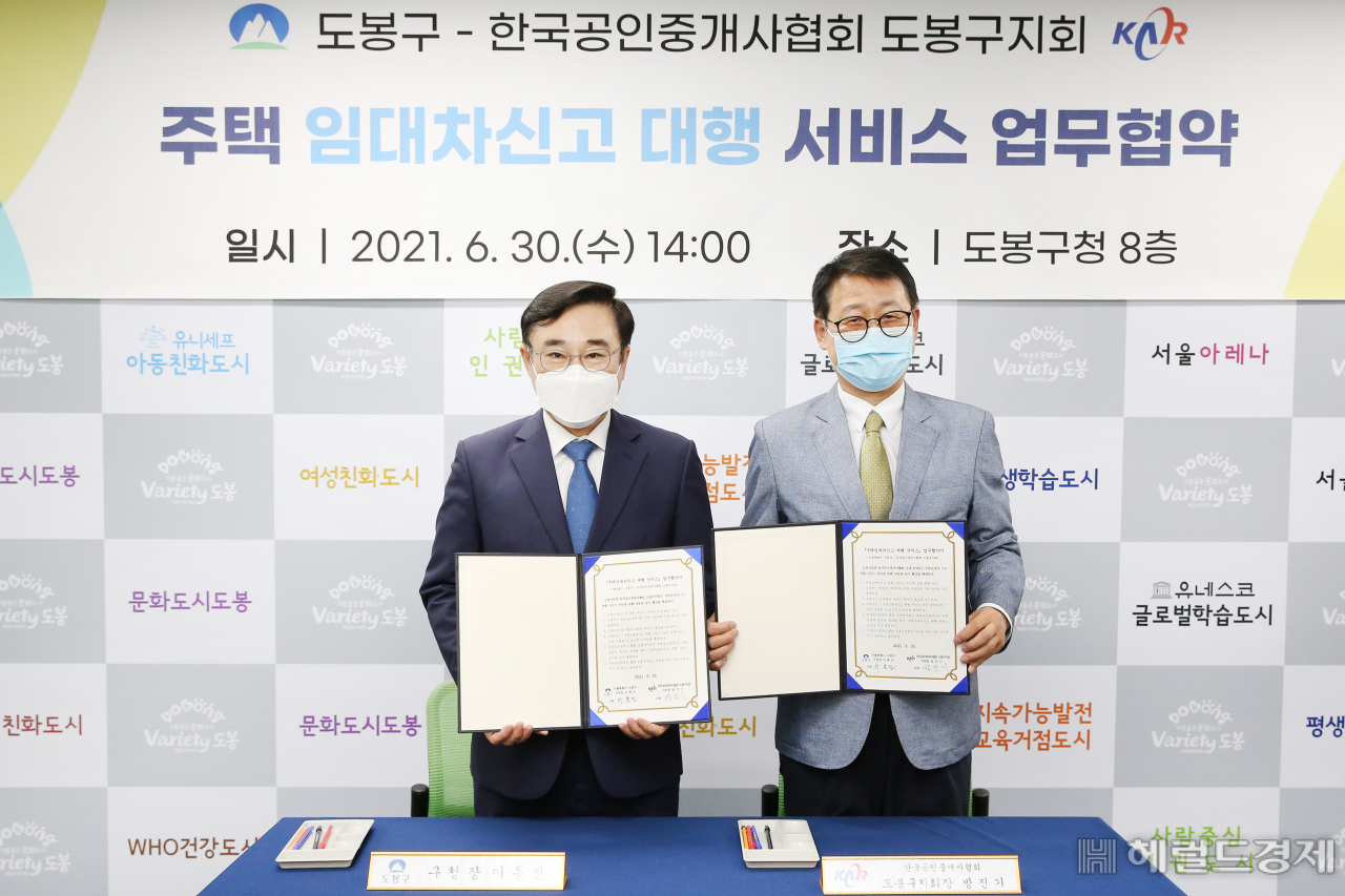 이동진(왼쪽) 도봉구청장과 방진기 한국공인중개사협회 도봉구지회장이 주택 임대차신고 대행 서비스 업무협약을 체결한뒤 기념사진을 찍고 있다. [도봉구 제공]
