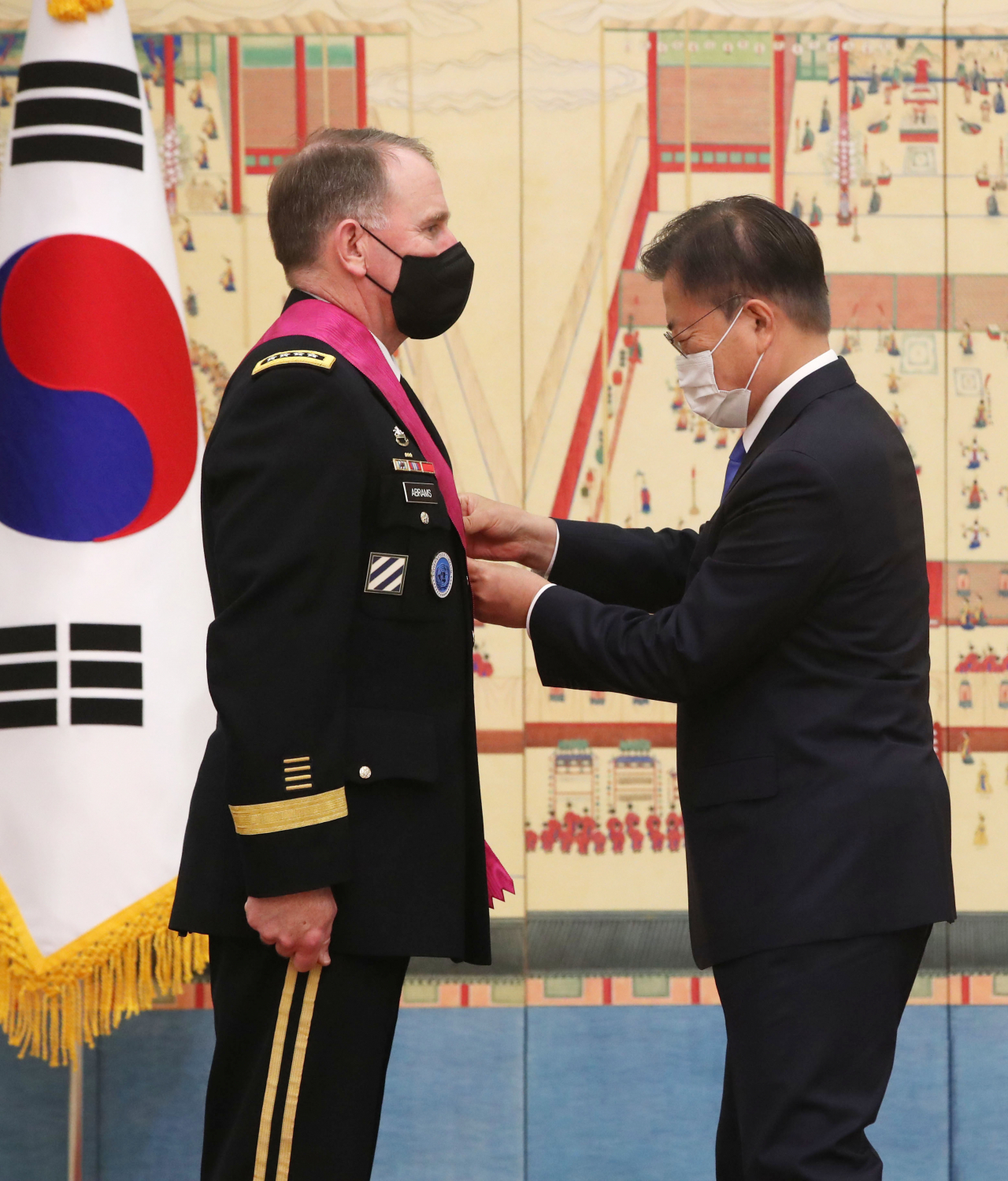 문재인 대통령이 1일 청와대에서 이임하는로버트 에이브럼스 한미연합사령관 겸 주한미군사령관에게 보국훈장 통일장을 수여하고 대수를 걸어주고 있다. 연합뉴스