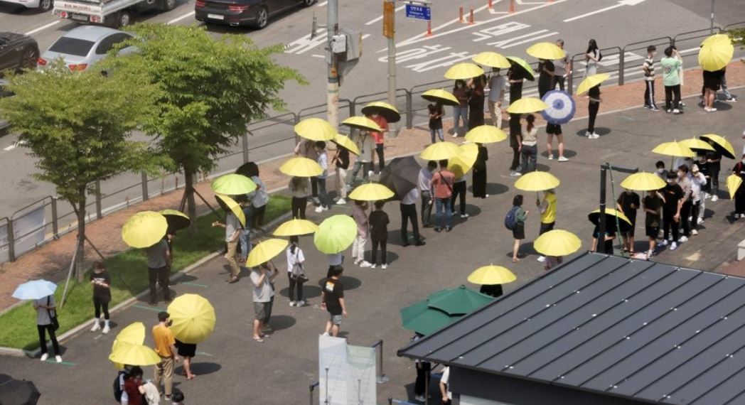 Citizens wait in line with umbrellas for COVID-19 tests in southern Seoul on July 2, 2021. (Yonhap)