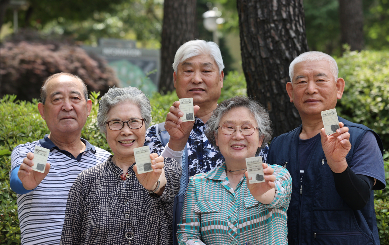 지난 1일 서울 동작구 상도1동주민센터에서 시민들이 코로나 예방접종 스티커를 발급받아 신분증에 부착한 뒤 야외에서 마스크를 벗고 활짝 웃고 있다. 수도권의 새 사회적 거리두기 시행 유예와 별개로 백신 접종자에 대한 인센티브는 이날부터 전국적으로 시행된다. 백신을 한 번이라도 맞았다면 공원, 산책로 등 야외에서 마스크를 벗을 수 있고 사적모임 인원제한 기준에서도 제외된다. [연합]