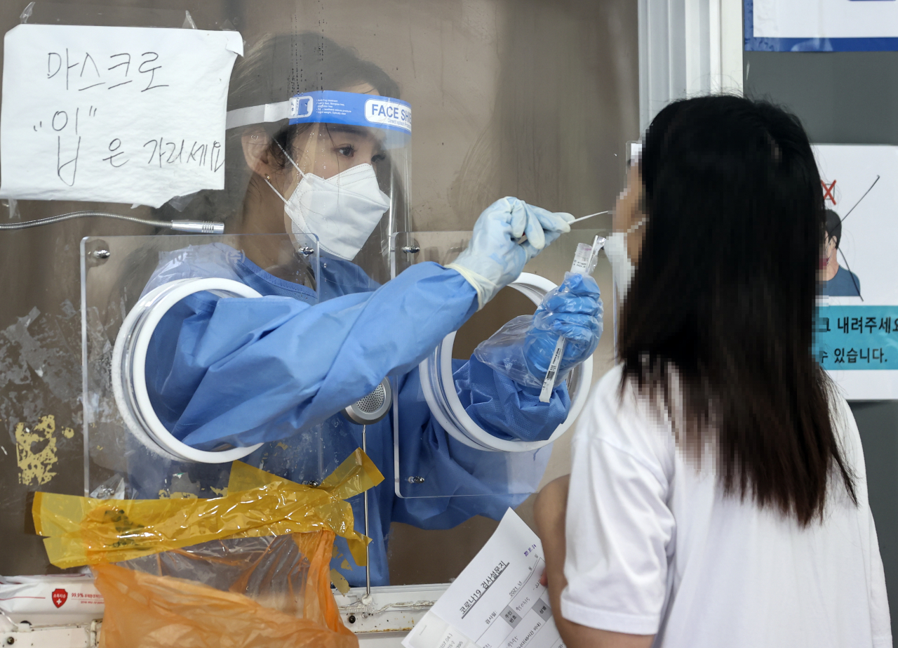 국내 신종 코로나바이러스 감염증(코로나19) 확산세가 지속하면서 신규 확진자 수 700명대 중반을 기록한 4일 오전 서울역에 설치된 임시선별검사소에서 시민이 검사를 받고 있다. 연합뉴스