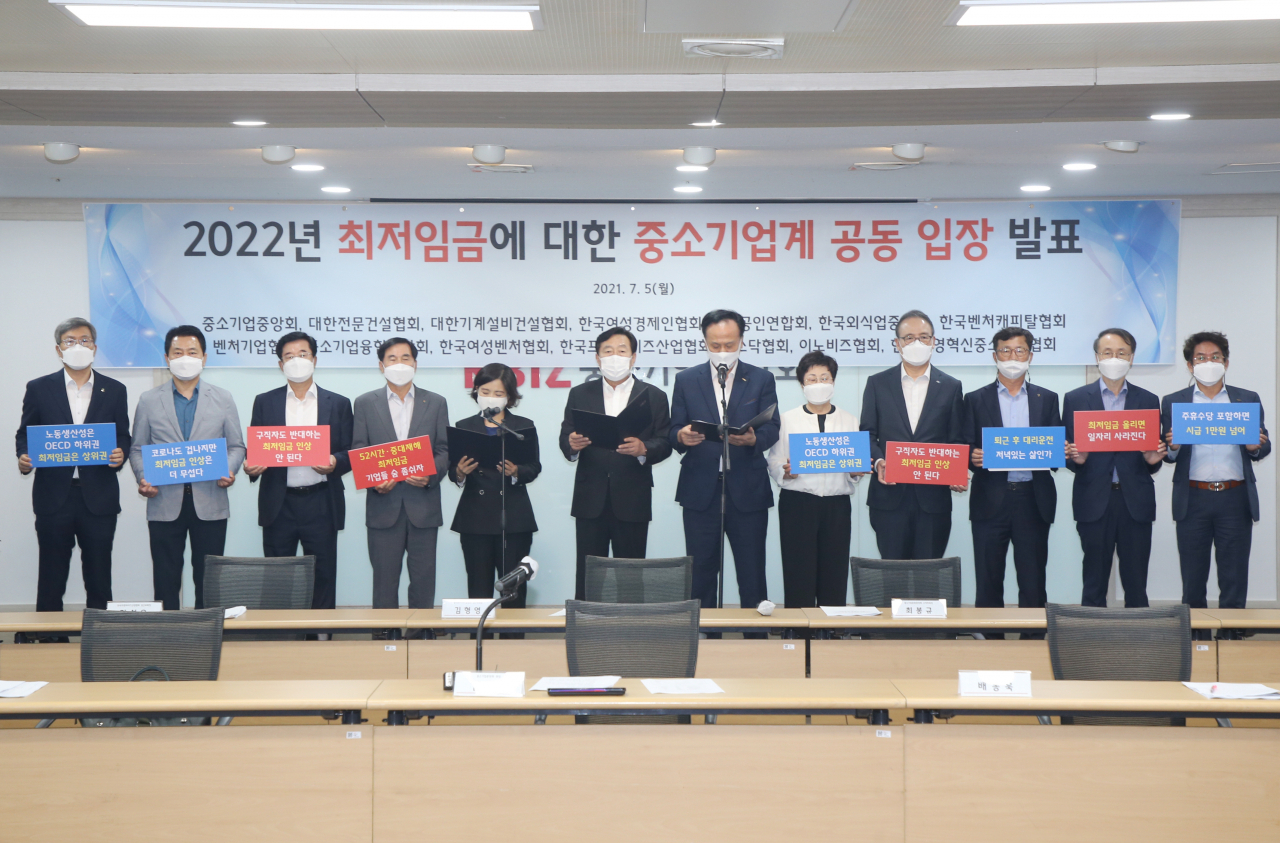 (왼쪽 5번째부터) 김분희 여성벤처협회장과 김기문 중기중앙회장, 배동욱 소상공인연합회장 등 중소기업단체협의회 대표 12명이 5일 여의도 중소기업중앙회에서 최저임금 관련 중단협 공동 입장을 발표하고 있다.[제공 중소기업중앙회]