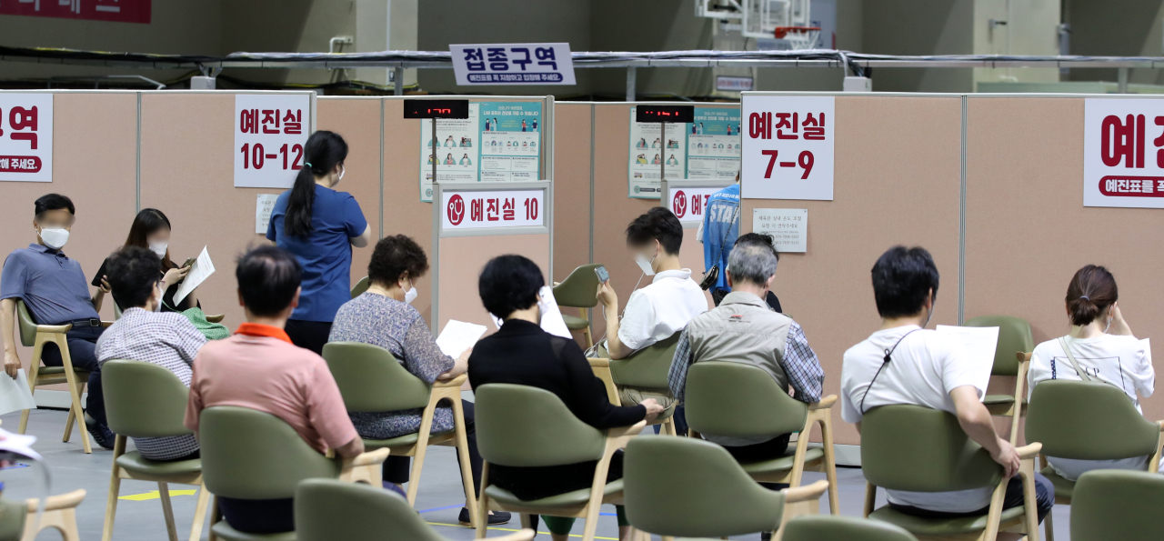 People wait for their turn to receive COVID-19 vaccine at a temproary vaccination center made in Dongjak-gu, southern Seoul, on Monday. (Yonhap)