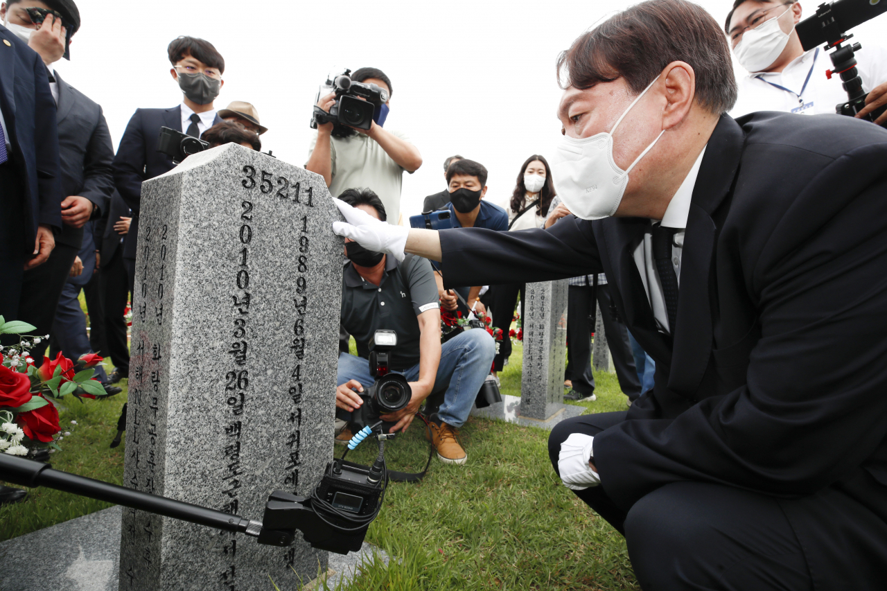 대선 출마를 선언한 윤석열 전 검찰총장이 6일 오전 대전 유성구 국립대전현충원에서 현충탑 참배를 한 뒤 천안함 46용사 묘역을 찾아 묘비를 살펴보고 있다. [연합]