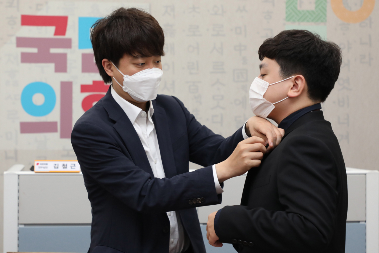 이준석 국민의힘 대표가 지난 6일 오전 국회 당대표실에서 열린 신임 대변인단 티타임에서 임승호 대변인 내정자에게 당 배지를 달아주고 있다. [이상섭 기자/babtong@heraldcorp.com]