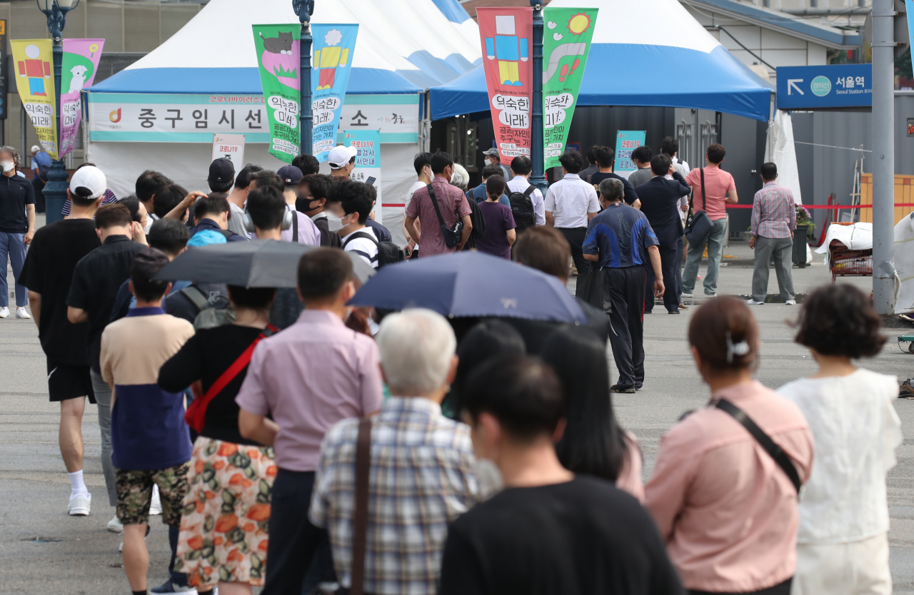 하루 신종 코로나바이러스 감염증(코로나19) 신규 확진자 수가 1200명을 넘어선 7일 오전 서울 중구 서울역 임시 선별검사소에서 시민들이 검사를 위해 길게 줄지어 서 있다. [연합]