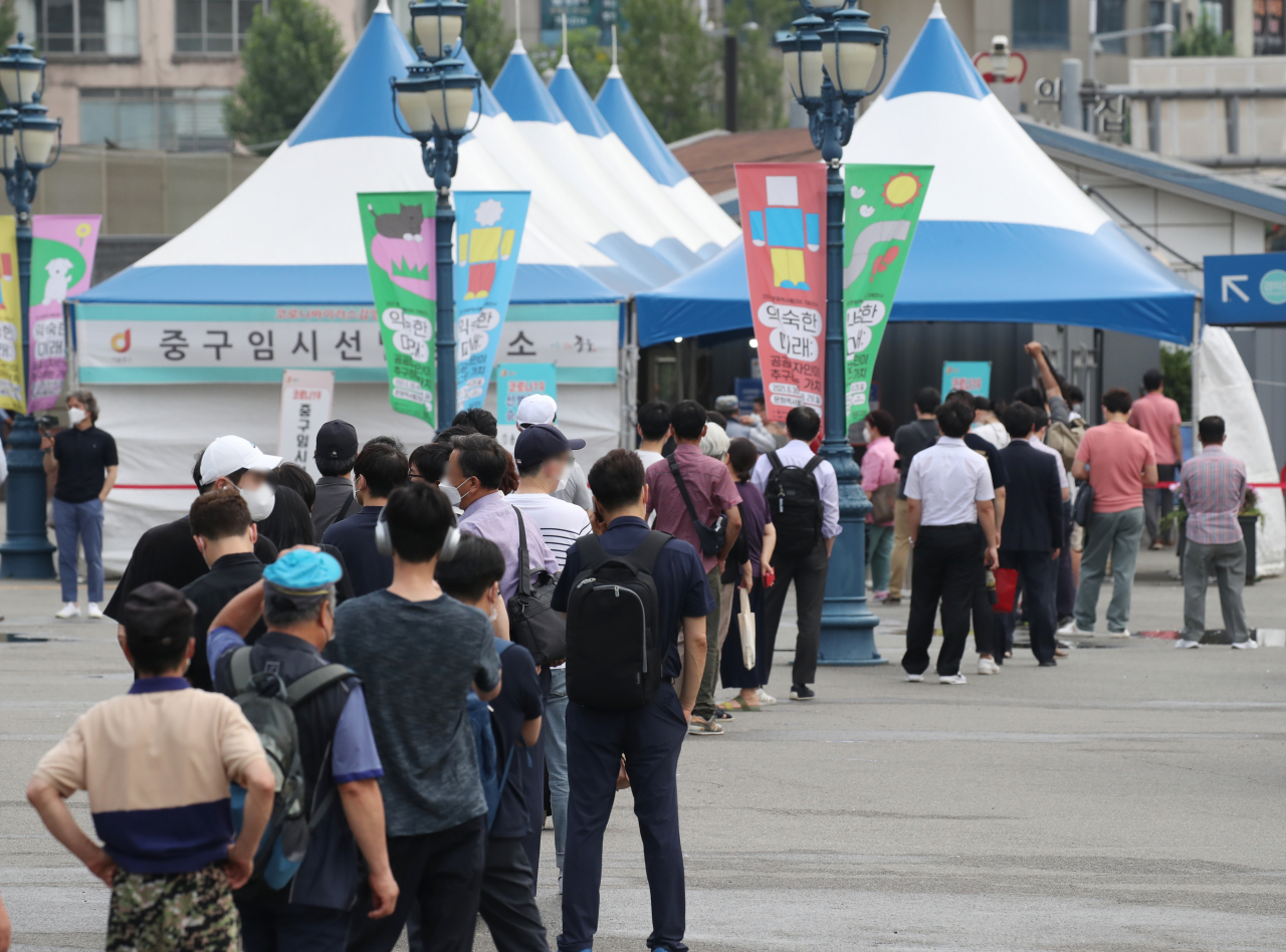 하루 신종 코로나바이러스 감염증(코로나19) 신규 확진자 수가 1200명을 넘어선 7일 오전 서울 중구 서울역 임시 선별검사소에서 시민들이 검사를 위해 길게 줄지어 서 있다. [연합]